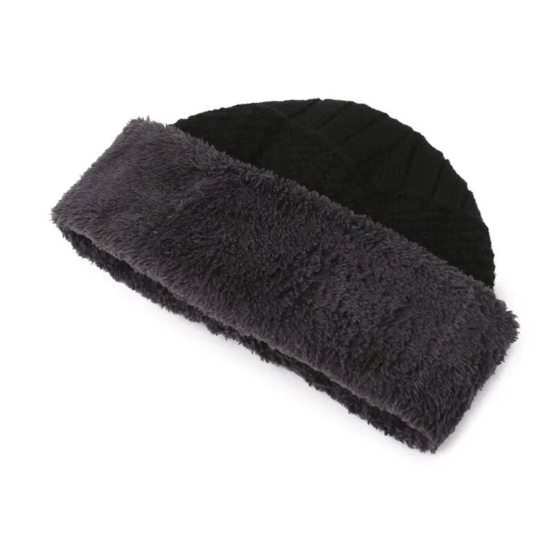 A black cable-knit winter beanie featuring a soft, grey faux-fur fleece lining.