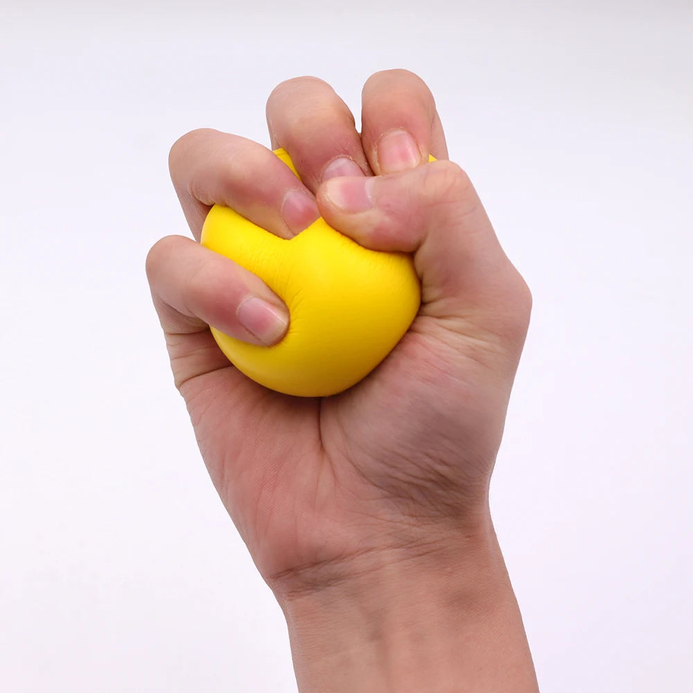 A hand squeezing a bright yellow stress ball against a white background.