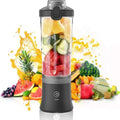 Portable black electric blender filled with fresh fruit and vegetables, set against a colorful fruit splash background.