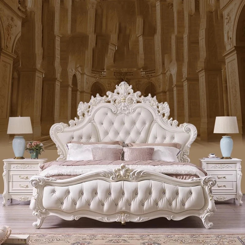 Luxury cream tufted princess bed with an ornate, carved wooden headboard, footboard, and matching bedside tables.