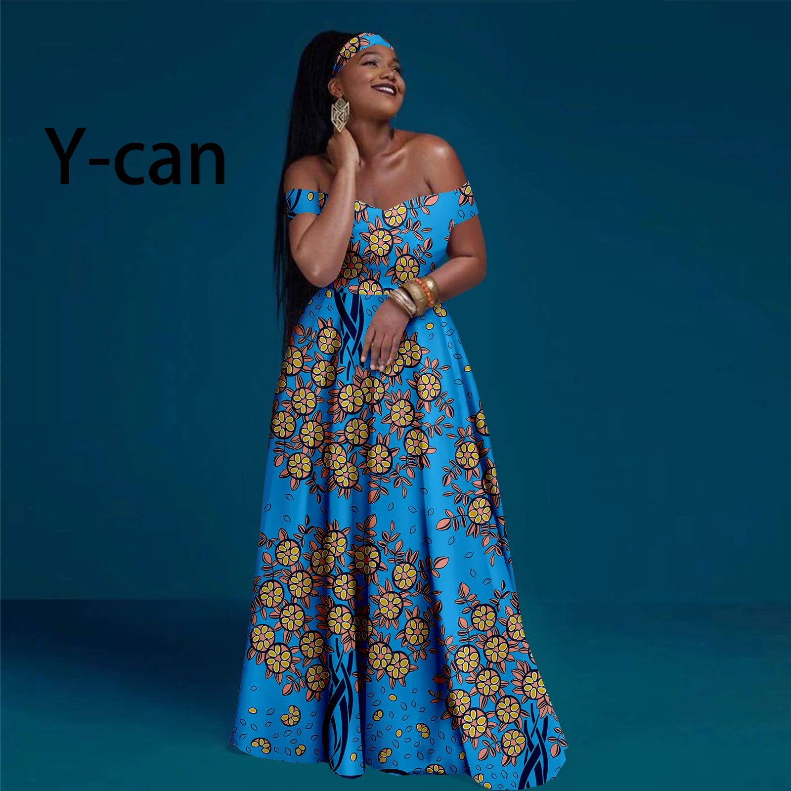 Model wearing a blue off-shoulder maxi dress with a yellow and orange floral print and matching headband.
