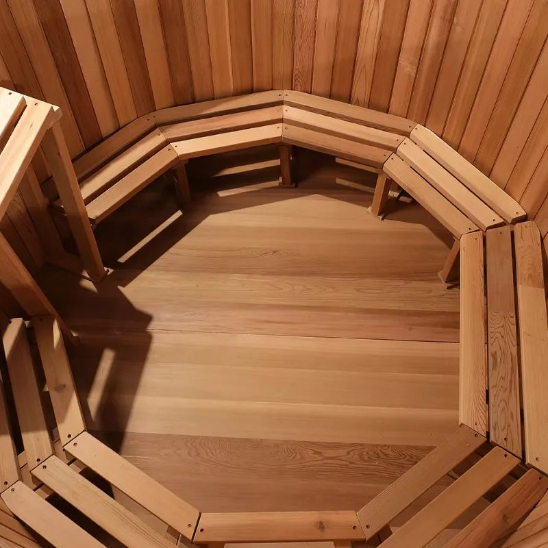 Interior of a wooden barrel sauna with slatted benches lining the curved walls.