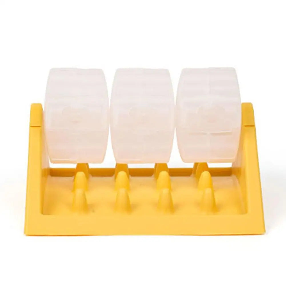 Yellow dog puzzle feeder with three clear, rotating treat-dispensing cylinders on a textured base.