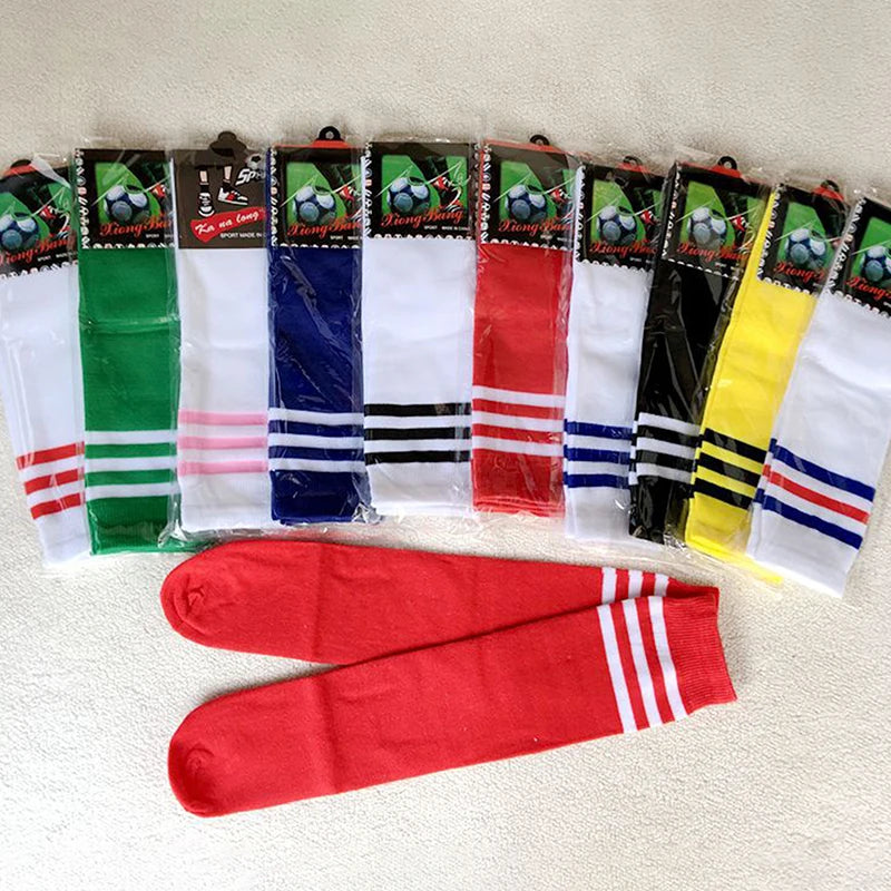 Assorted coloured football socks in individual packaging, featuring three-stripe detailing at the top.
