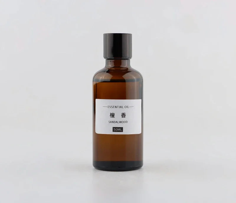 Amber glass bottle of sandalwood essential oil with a black cap and white label, 50ml size.