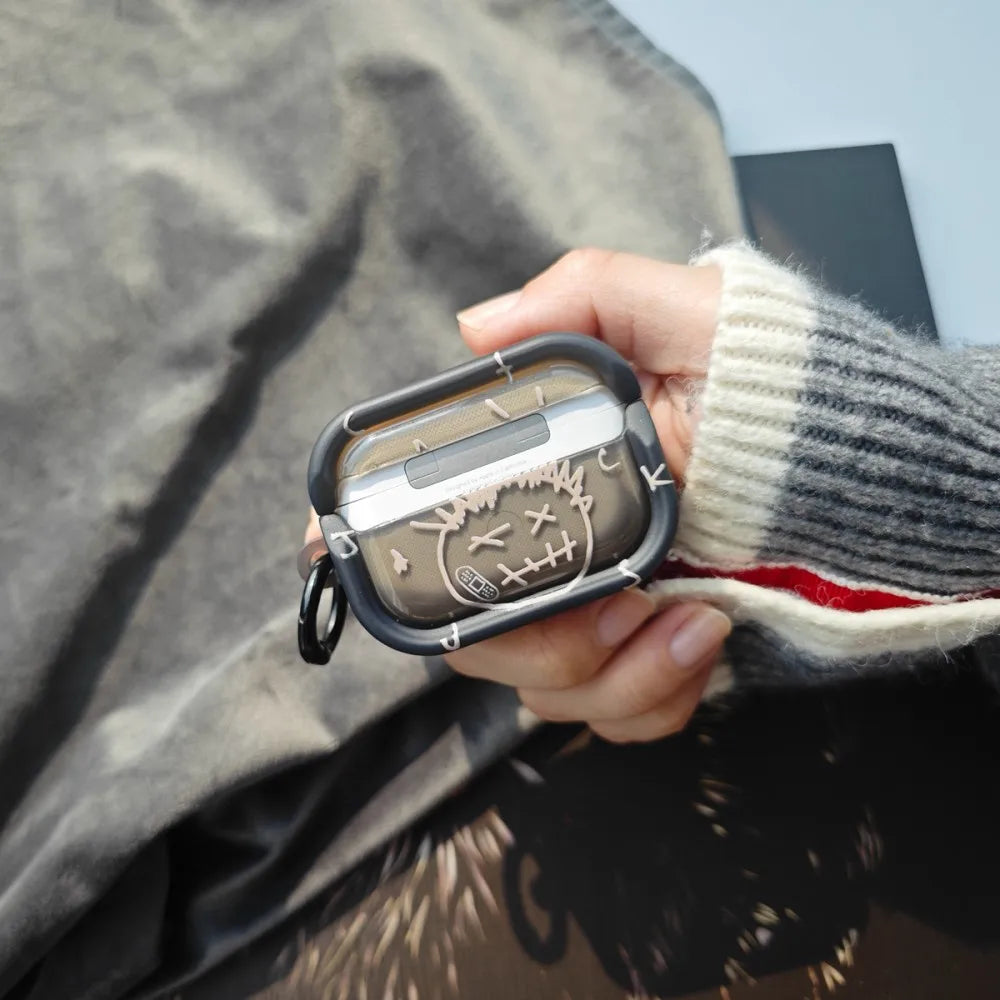 Black silicone AirPods Pro case featuring a white Cactus Jack sketch and carry loop, held in hand.