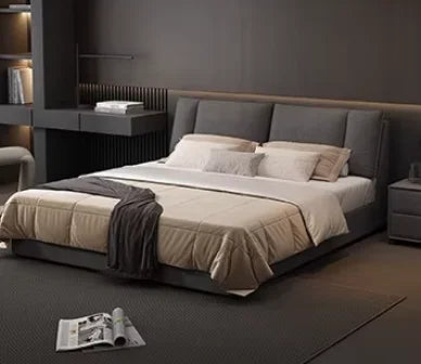 Modern, dark grey upholstered double bed with a tall panelled headboard and integrated storage in a minimalist bedroom.