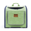 Green pet carrier backpack with a structured square form, zippered top opening, and a branded front pocket.