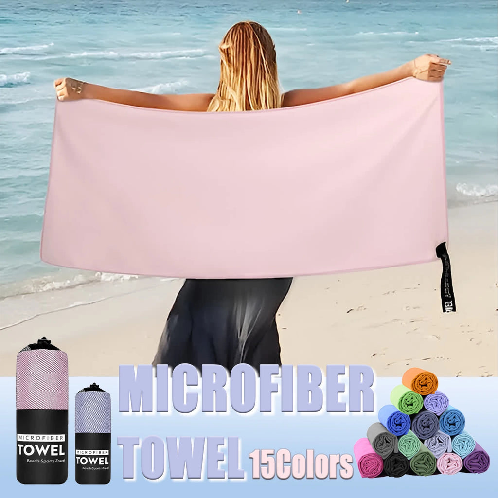 A woman holding a plain light pink microfiber beach towel on a beach, with rolled towels in 15 different colours.