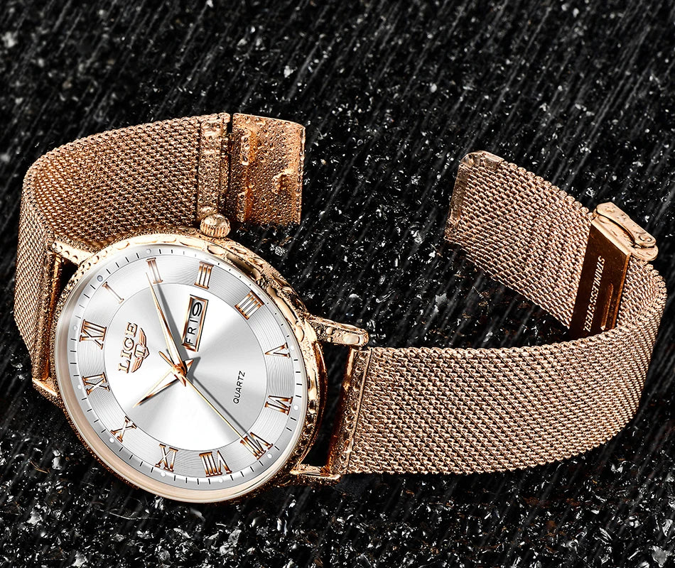 Elegant rose gold-tone women's watch with a stainless steel mesh strap and white face with Roman numeral markers.