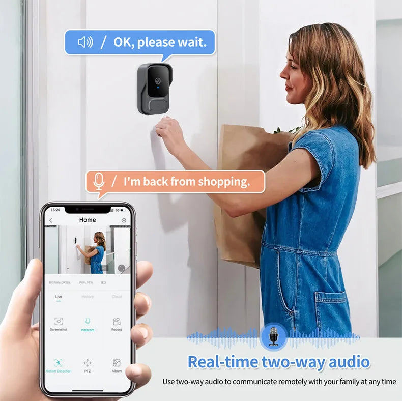 A woman using a compact, dark grey wireless video doorbell, controlled via a smartphone app with two-way audio.