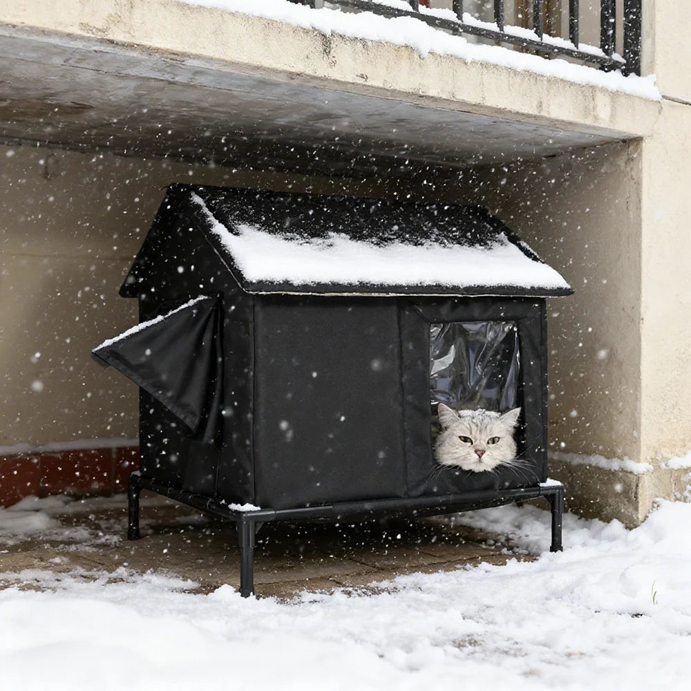 Black, waterproof, insulated outdoor cat shelter on a raised frame, featuring a clear window with a cat inside.