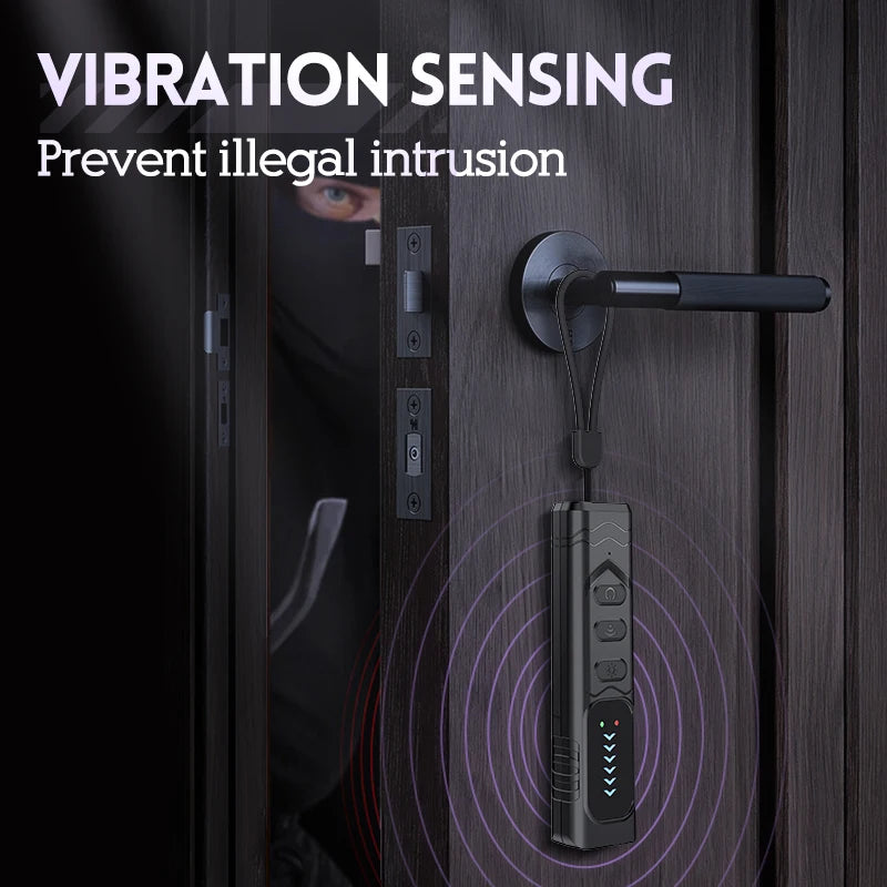 Black plastic portable vibration-sensing security alarm hanging from a door handle with indicator lights.