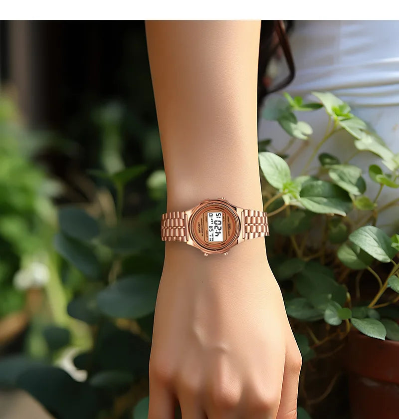 Rose gold retro-style digital watch with a matching link bracelet worn on a woman's wrist.