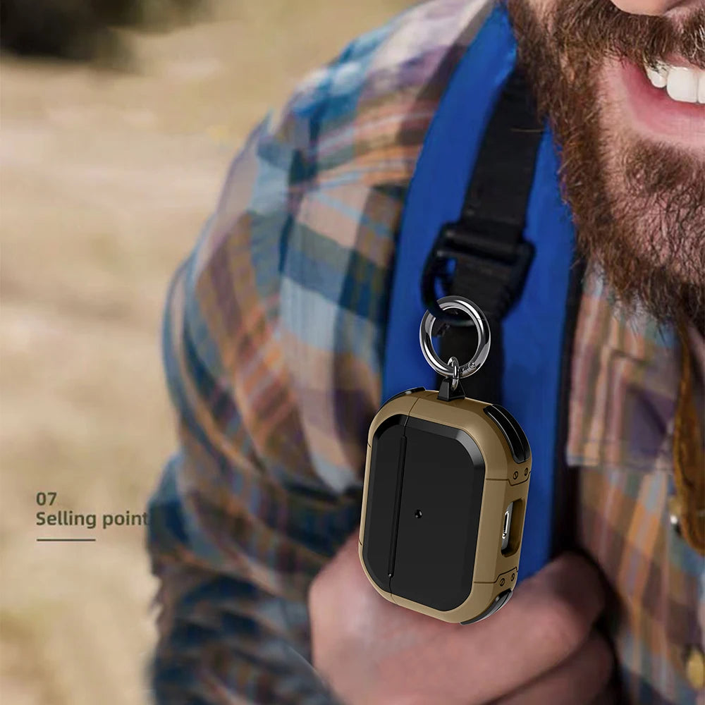 Rugged khaki and black protective AirPods case with keyring clip attached to a rucksack strap.