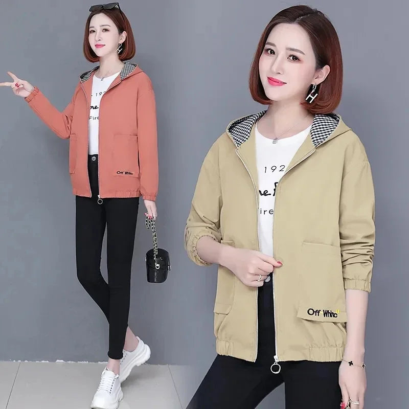 Woman wearing a zip-up hooded jacket with a gingham-lined hood, available in peach and khaki.