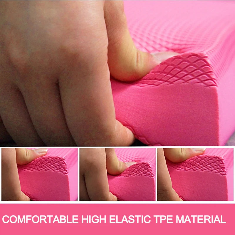 Close-up of a hand pressing into a pink, textured TPE foam balance pad, showing its soft and elastic quality.