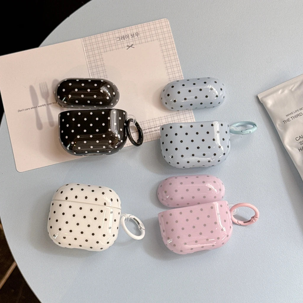 Polka dot glossy AirPod cases with matching carabiners in black, blue, white, and pink.