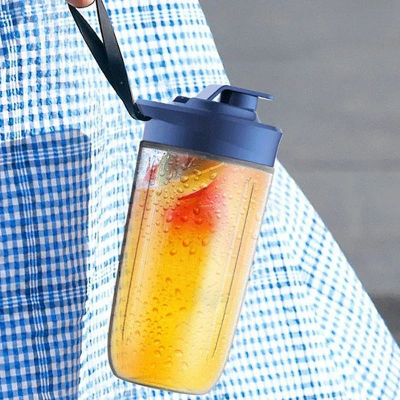 Portable blender cup with a dark blue lid and black carry strap, filled with a vibrant yellow fruit smoothie.