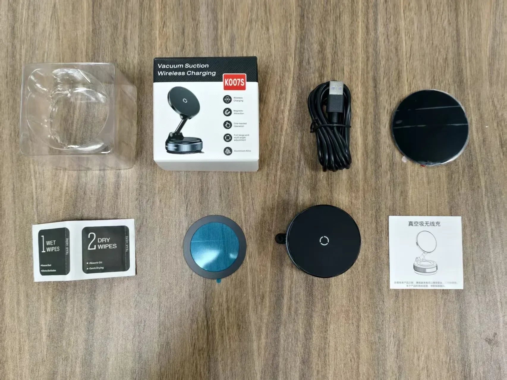 Black vacuum suction wireless charger set with USB cable, manuals, wipes, and packaging on a wooden surface.
