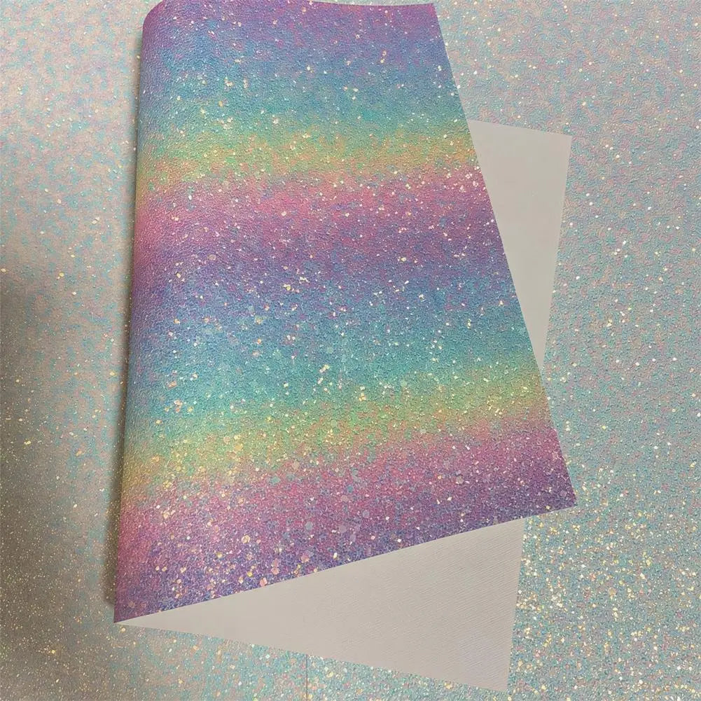 A sheet of iridescent rainbow glitter craft fabric with a smooth white backing, shown partially folded.
