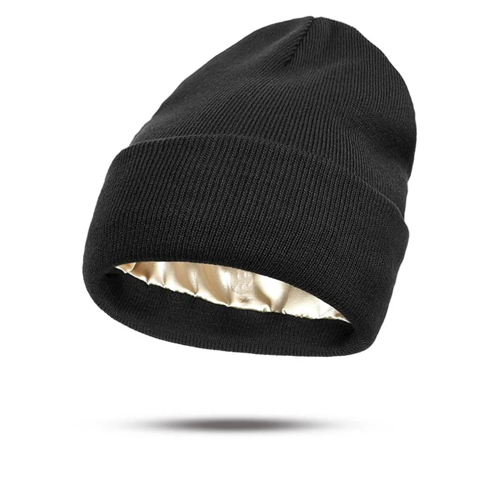 Black knitted beanie hat with a folded brim and a smooth champagne-coloured satin lining.