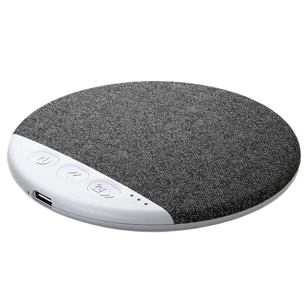 Round wireless sleep speaker in grey fabric with a white trim, featuring playback buttons and a USB charging port.