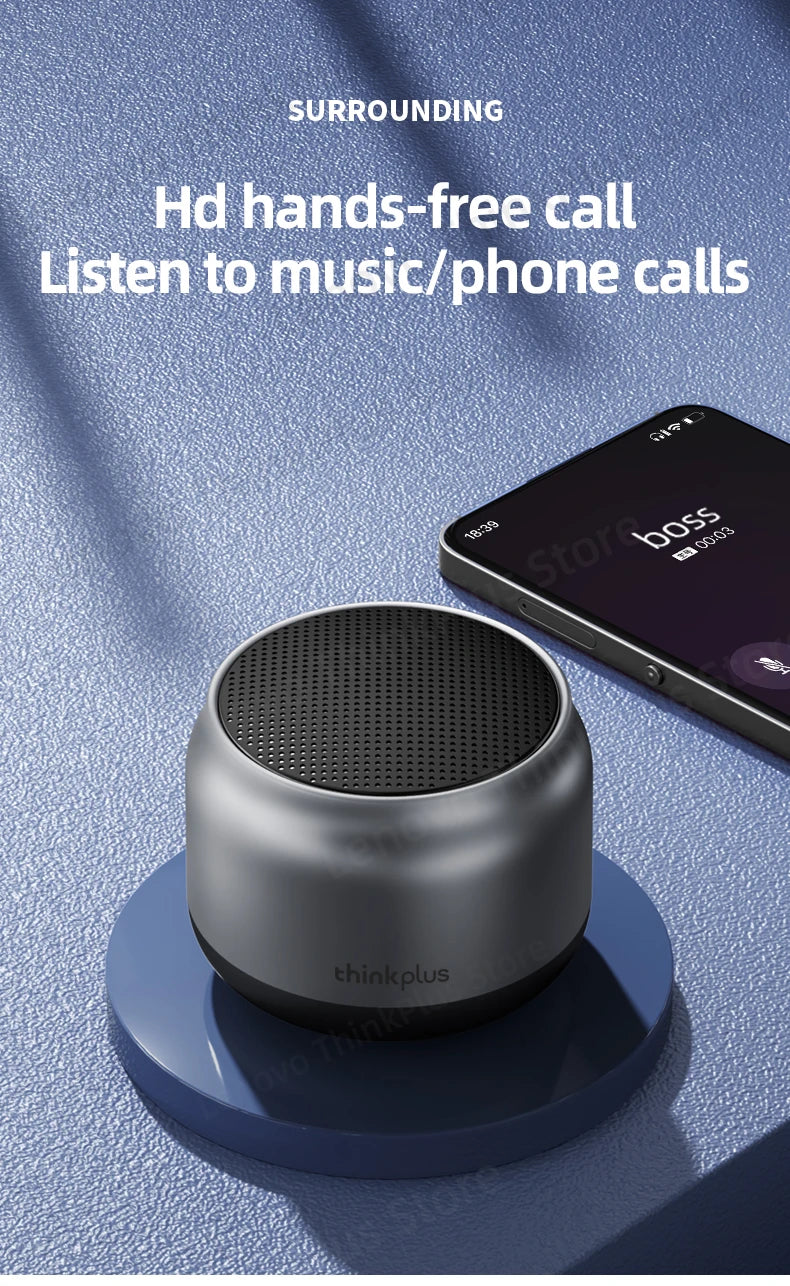 Compact, metallic grey wireless speaker with a black top grille, shown next to a smartphone for hands-free calls.