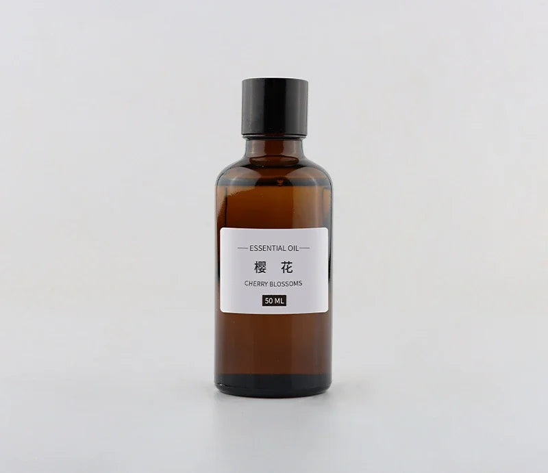 Amber glass bottle of Cherry Blossom essential oil with a black cap, 50ml size, on a white background.