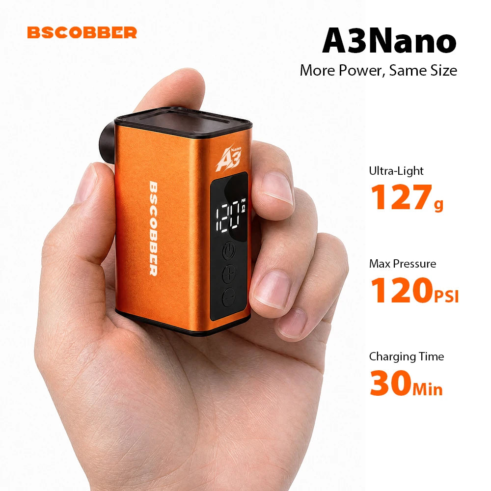 Hand holding a compact orange BSCOBBER A3Nano mini electric air compressor with a digital display screen.
