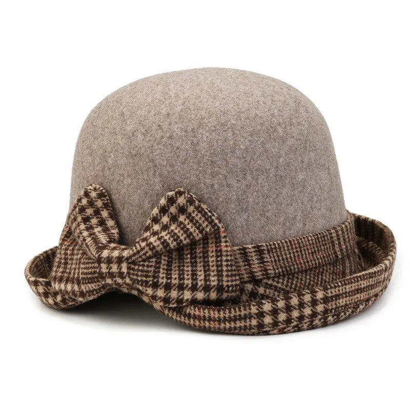 Women’s grey felt winter bucket hat featuring a brown and cream houndstooth trim and a decorative side bow.