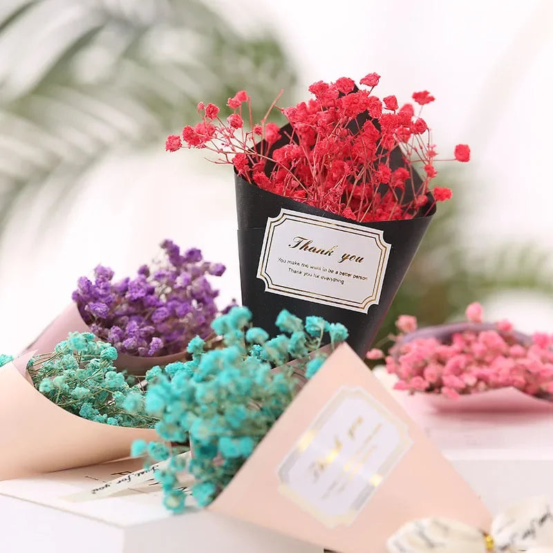 Small bouquets of colourful dried flowers in black and pastel paper wraps with 'Thank you' labels.