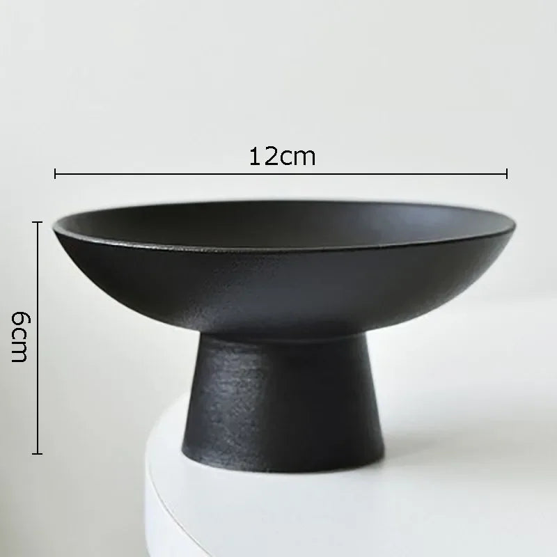 Minimalist matte black pedestal bowl, 12cm wide and 6cm tall, featuring a wide base and shallow dish design.