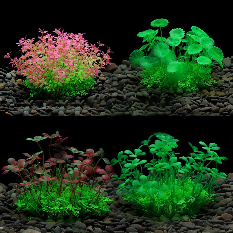Four colorful artificial aquarium plants with varied leaf shapes, set on a dark gravel bed against a black background.