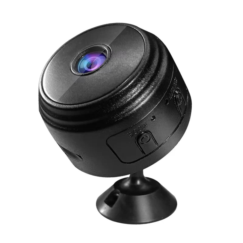 Small black plastic round security camera on a stand with a prominent central lens and side buttons.