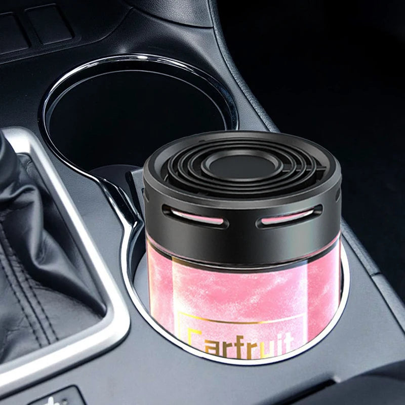 Black car air freshener with a pink metallic base, designed to sit neatly inside a vehicle cup holder.