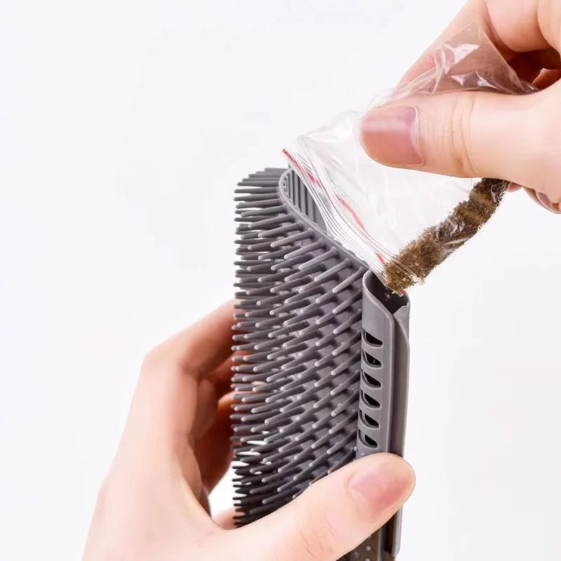 Grey silicone pet wall brush being filled with a small pouch of catnip.