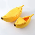 Two yellow banana-shaped plush pet beds with brown tips, one closed and one with a peeled-back flap.