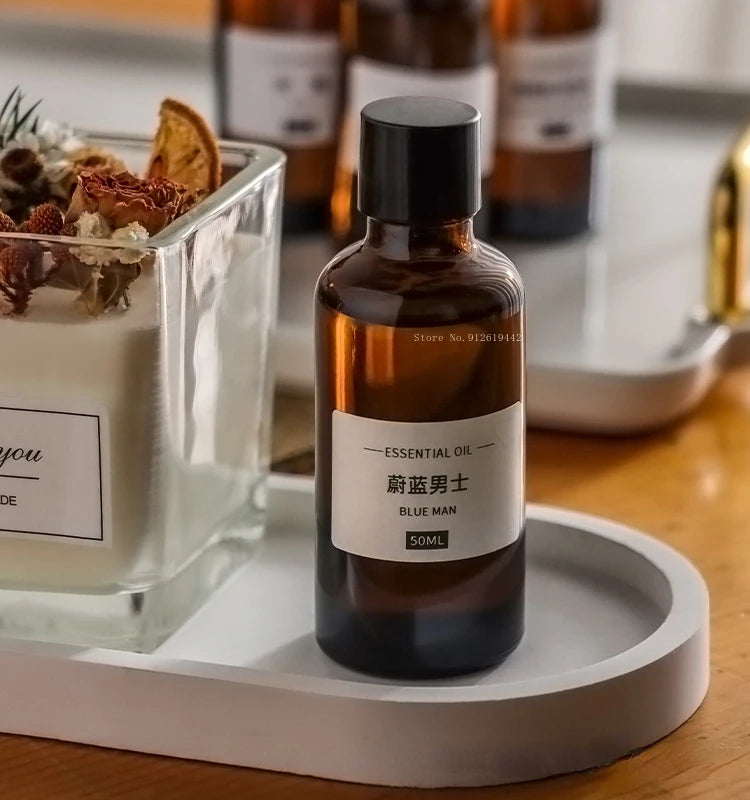 Amber glass 50ml essential oil bottle with a black cap and minimalist label on a white tray.