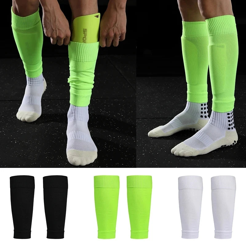 Bright neon green football shin guard sleeves being worn over socks, plus pairs in black, green, and white.