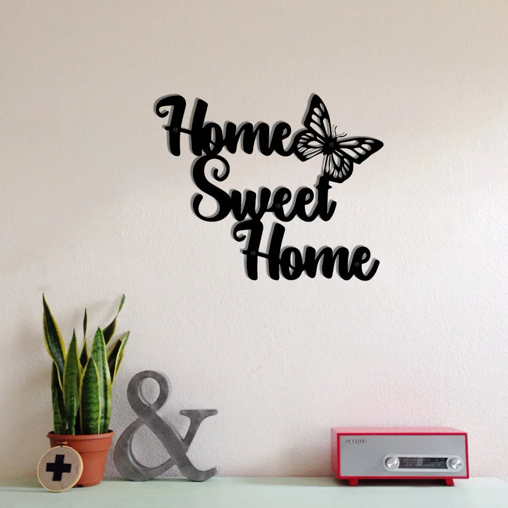 Black metal wall art featuring the text "Home Sweet Home" with an elegant butterfly detail, displayed on a wall.