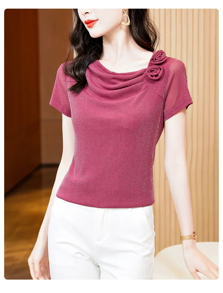 Shimmering berry-pink short-sleeve top with a cowl neckline and decorative rose floral detailing on the shoulder.