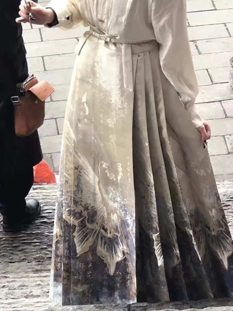 Cream-coloured maxi skirt with pleated detailing, a tie waist, and an elegant nature-inspired ink-wash print.