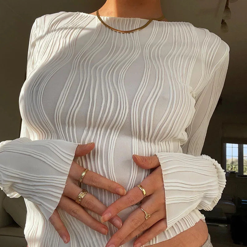 White long-sleeved top with a slim fit, round neck, and distinctive vertical wave-textured fabric.