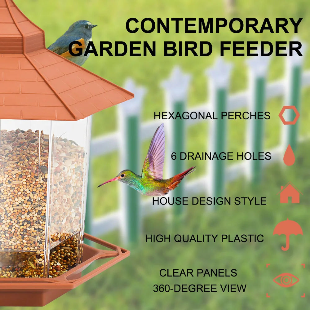 Hexagonal house-style bird feeder in terracotta plastic with clear panels for a 360-degree view, filled with seeds.