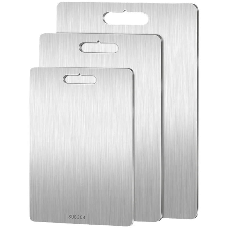 Three rectangular stainless steel cutting boards in graduated sizes, each with a hanging slot.