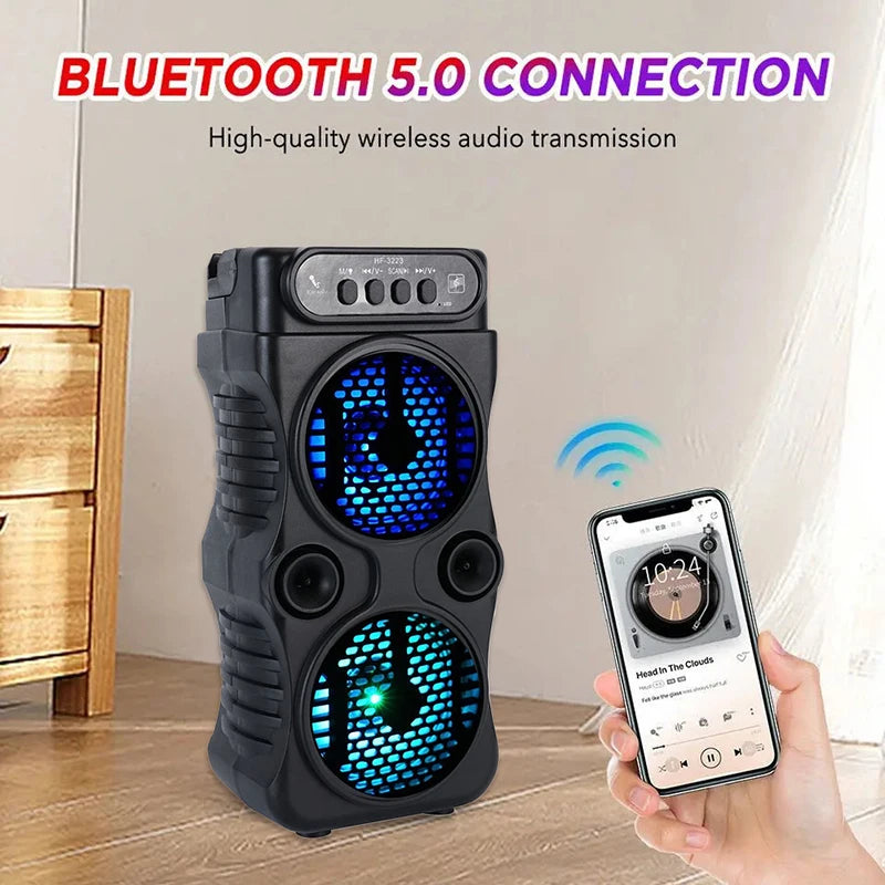 Portable black wireless speaker with dual glowing blue LED drivers and top control panel, being controlled by a phone.