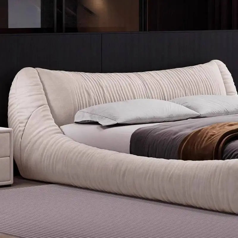 Modern cream-coloured upholstered bed frame with a textured, curved headboard and low-profile design.