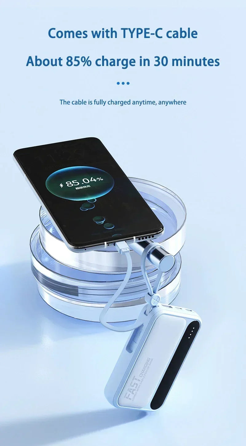 Light blue portable power bank with a built-in Type-C cable charging a smartphone to 85% in 30 minutes.