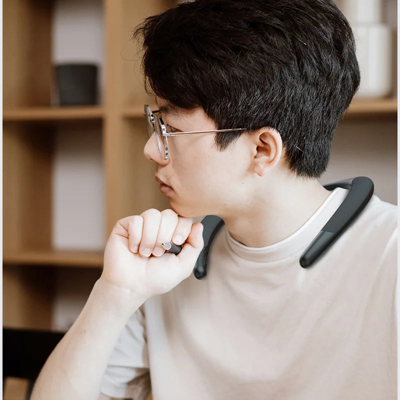 A person wearing a sleek, matte black wireless neckband speaker for portable, hands-free surround sound.